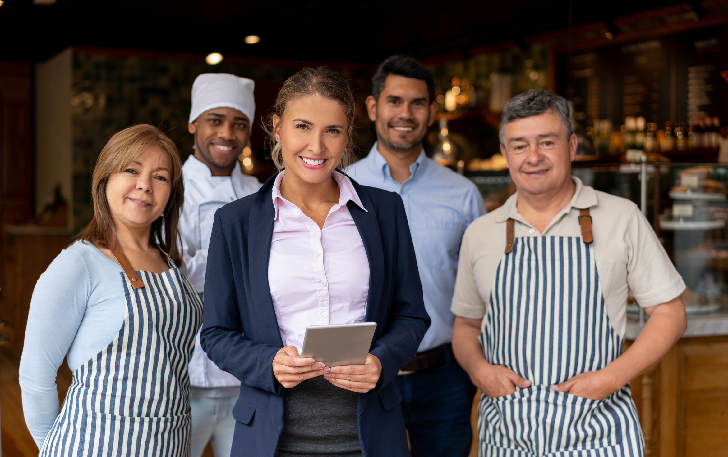 Happy business owner at a restaurant with her staff